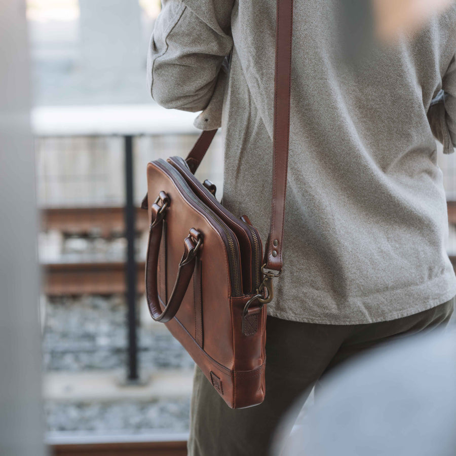Sleek brown leather attache bag with elegant handles and strap.