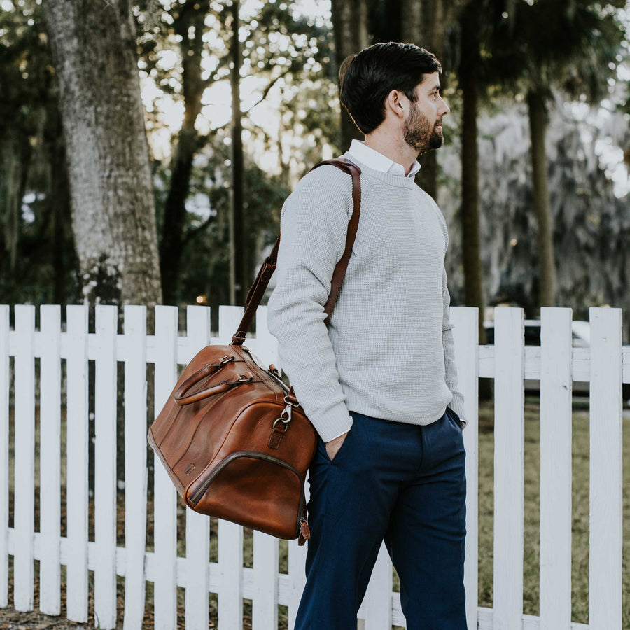 Premium tan leather weekender bag with spacious interior, reinforced stitching, and stylish brand logo.