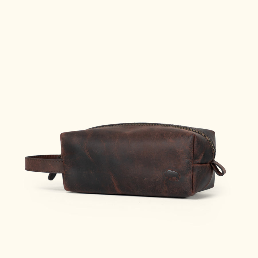Sleek Roosevelt travel toiletry bag in dark oak leather with a minimalist, functional design.